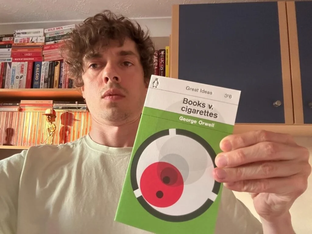 Tom holding his copy of Books v Cigarettes
